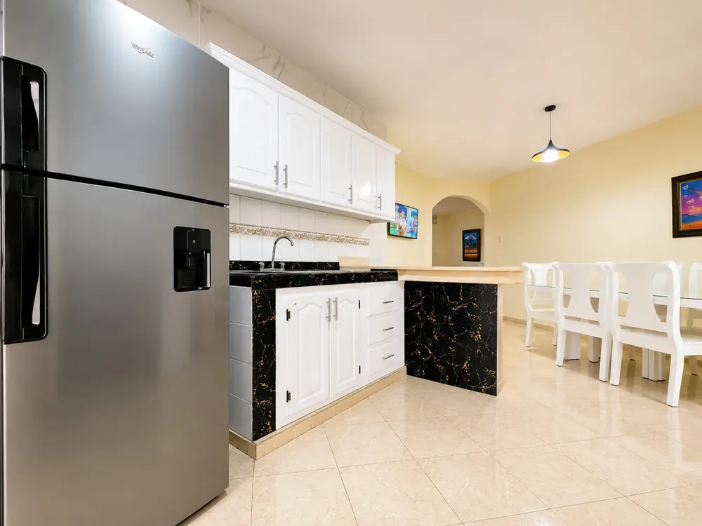 The kitchen with its full-size fridge and the breakfast bar