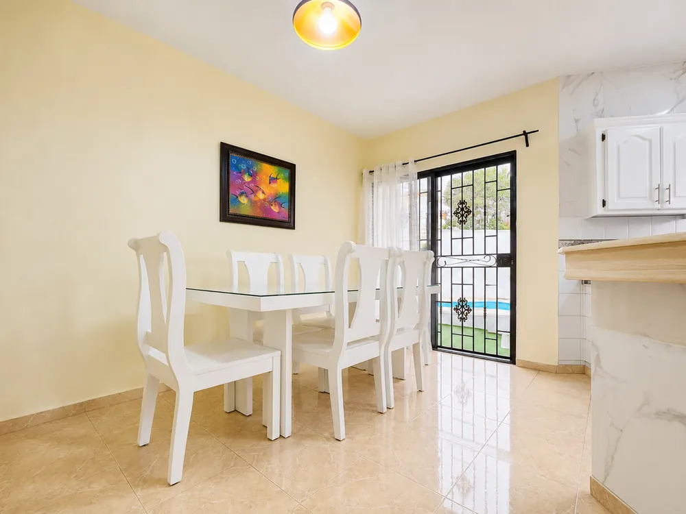 The dining table set for the group, beside the garden window