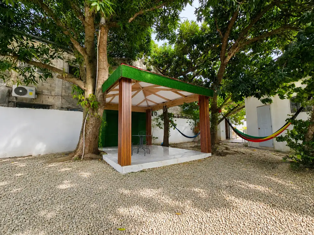 The wooden gazebo with hammocks slung between the trees beside it