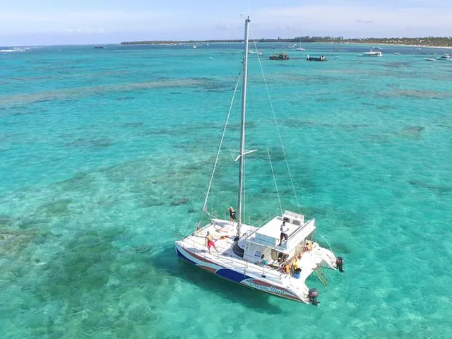 A catamaran anchored in clear turquoise water off Bávaro beach