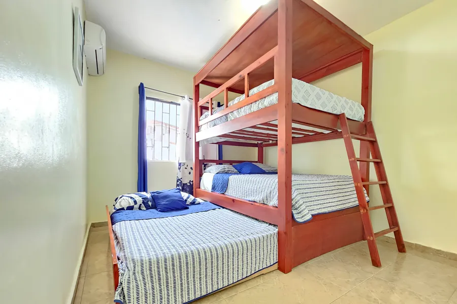 A bunk bed with a further bed pulled out alongside it